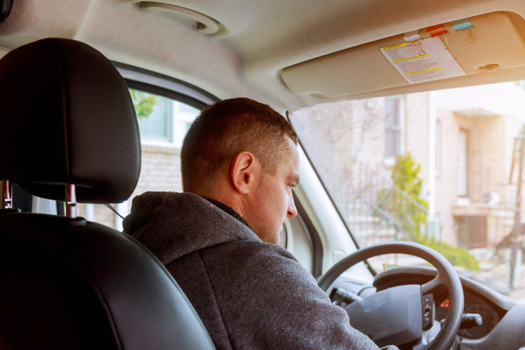 Driver with hand on the steering wheel of the truck