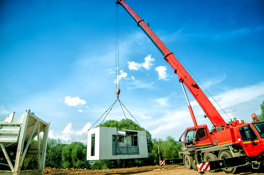 Crane lifting building parts at construction site