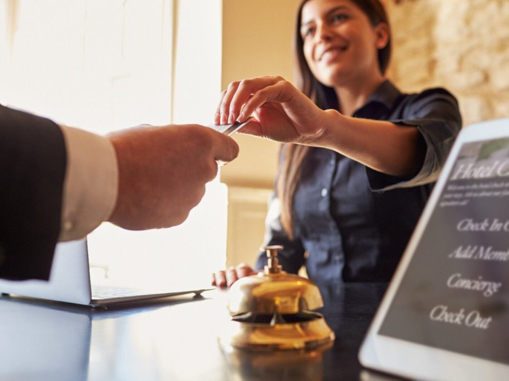 Hotel worker taking customer's credit card for payment