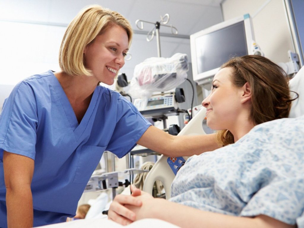 Nurse checking on patient after getting alert through nurse call system