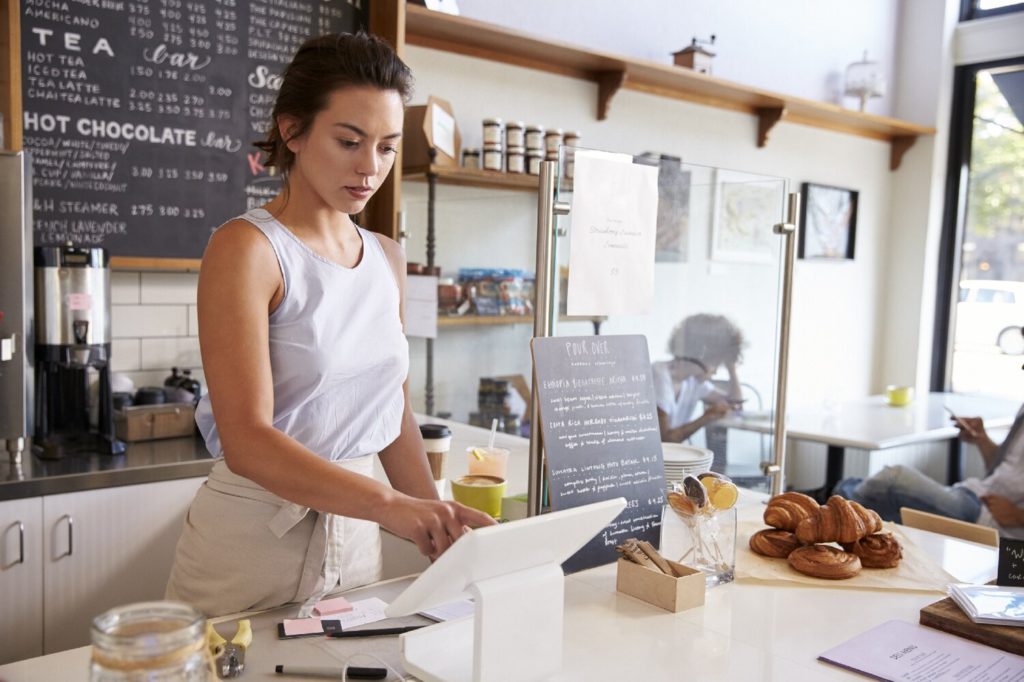 Employee using wifi powered tablet to take customer orders at coffee shop