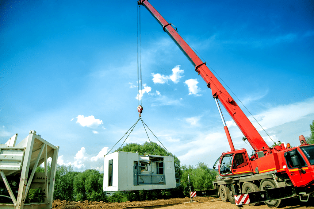 Crane lifting building parts at construction site